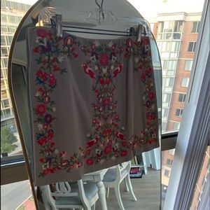 Gray mini skirt with embroidered birds and flowers.